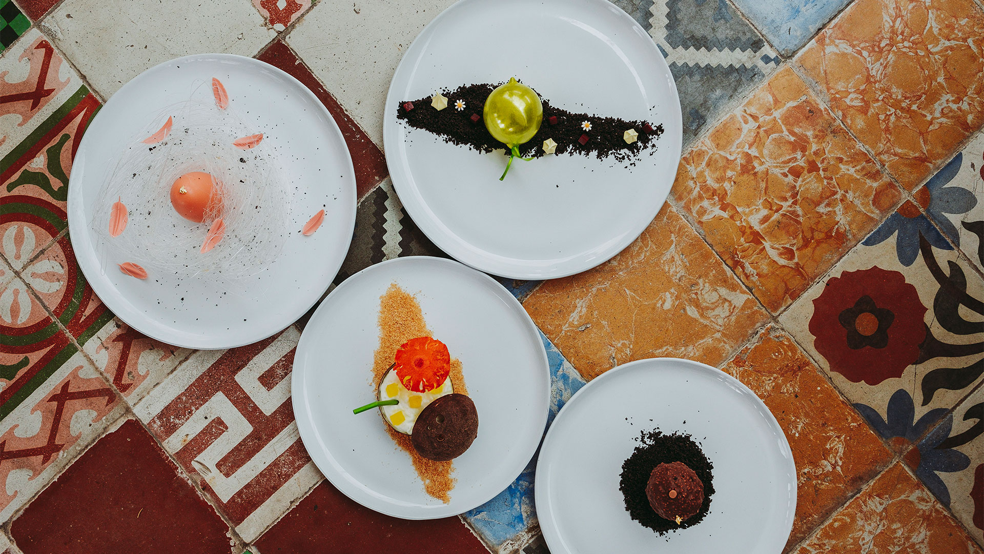 Gourmet desserts on white plates, showcasing artful presentation of culinary and cultural experiences at Banyan Tree Puebla.