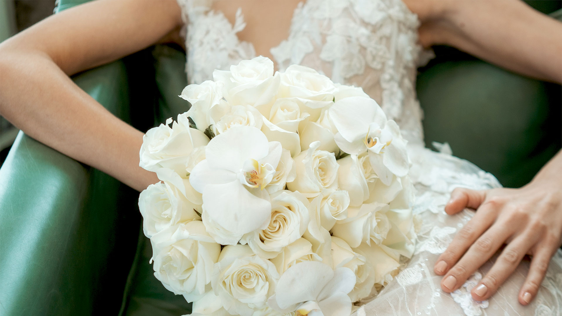 Bride holding white rose bouquet, seated on green chair at Banyan Tree Puebla.